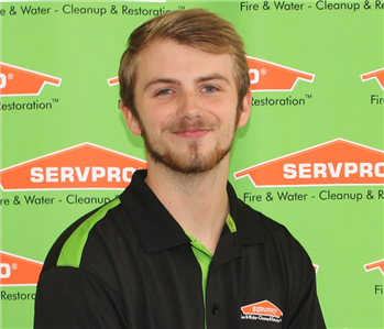 man in front of SERVPRO banner